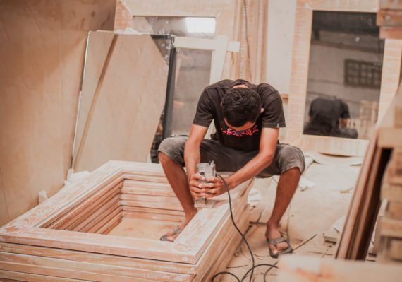 man in black t-shirt and black shorts sitting on brown wooden stairs