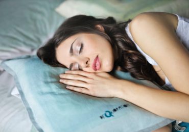 woman sleeping on blue throw pillow