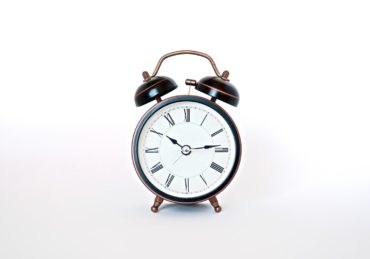 round black and white analog alarm clock