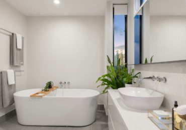 white ceramic bathtub near green potted plant