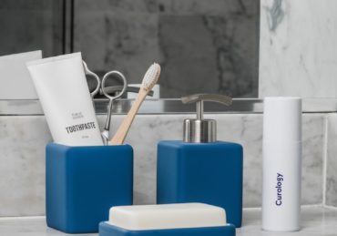 white soft-tube and brown brush in blue container beside pump bottle