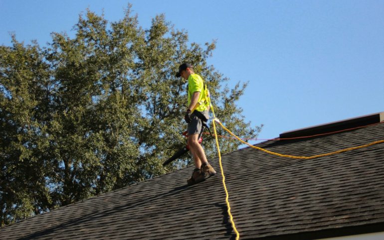 a man on a roof working with a rope